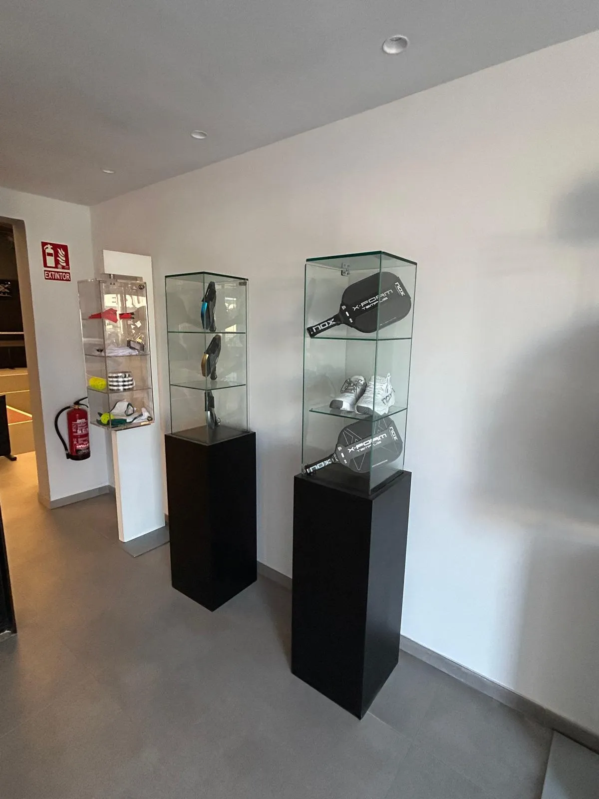 Vitrina con palas de pickleball en la tienda del club